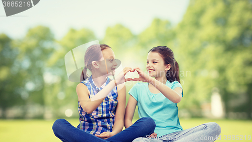 Image of happy little girls showing heart shape hand sign