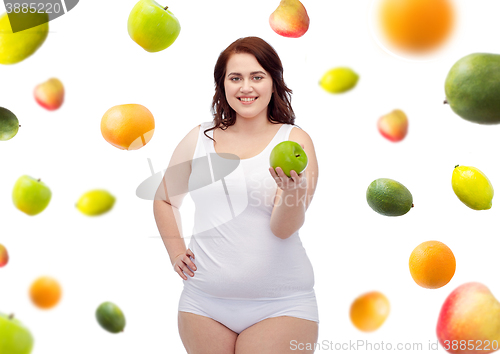 Image of happy plus size woman in underwear with apple
