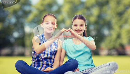 Image of happy little girls showing heart shape hand sign