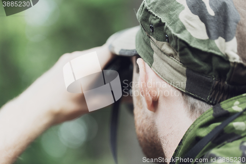 Image of close up of soldier or hunter with binocular