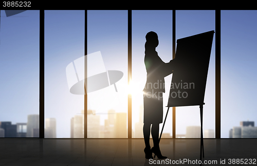 Image of silhouette of woman with flipboard over office