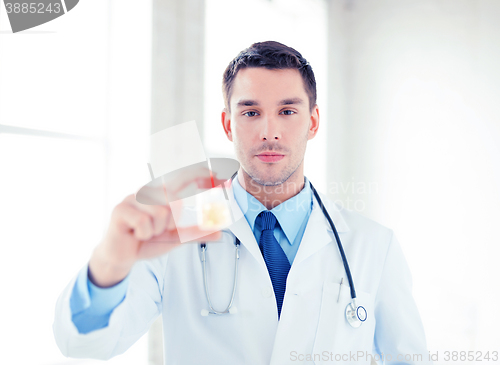 Image of male doctor with jar of capsules