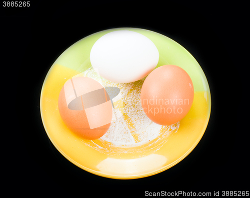 Image of eggs on a plate on black background