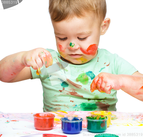 Image of Little boy is playing with paints