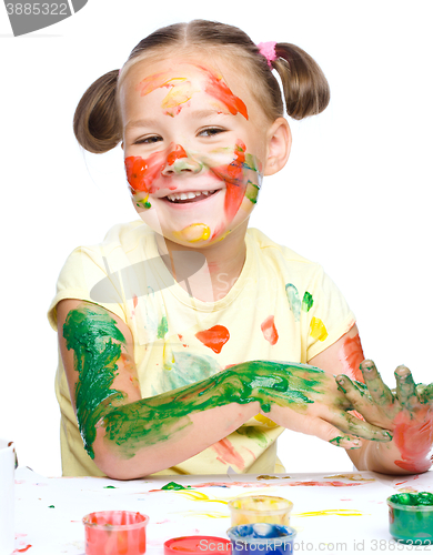 Image of Portrait of a cute girl playing with paints