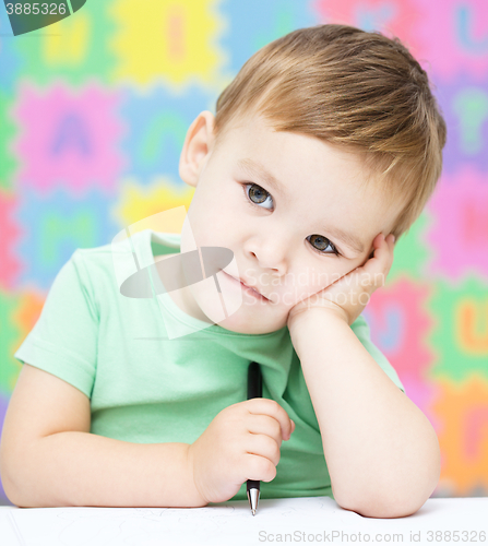 Image of Little boy is writing on his copybook