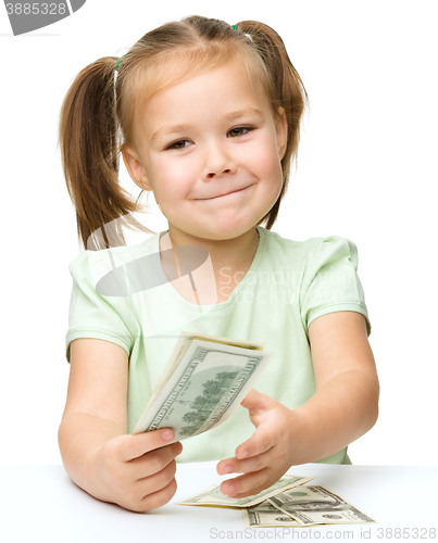 Image of Little girl is counting dollars