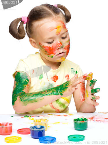 Image of Portrait of a cute girl playing with paints