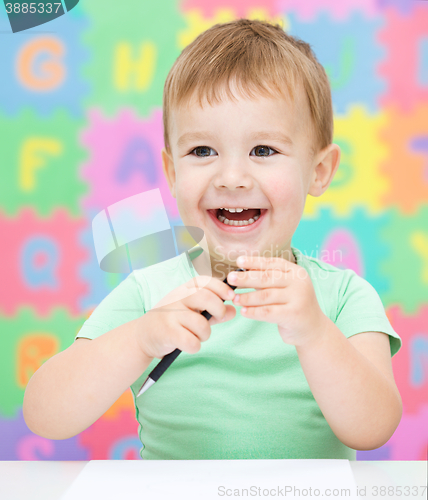 Image of Little girl is writing using a pen