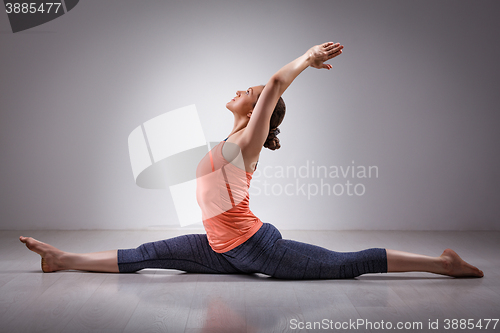 Image of Sporty fit woman doing yoga asana Hanumanasana 