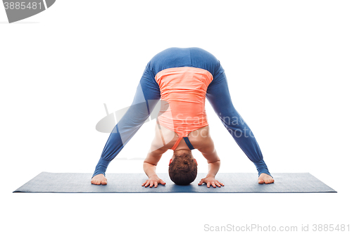 Image of Woman doing yoga asana Prasarita padottanasana