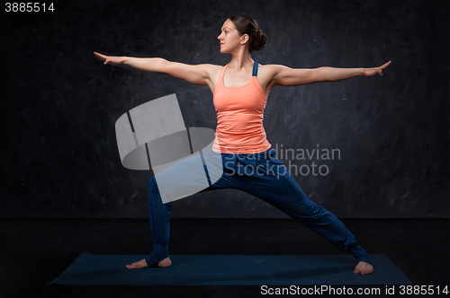 Image of Woman practices yoga asana utthita Virabhadrasana