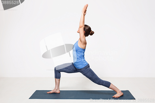 Image of Woman practices yoga asana utthita Virabhadrasana