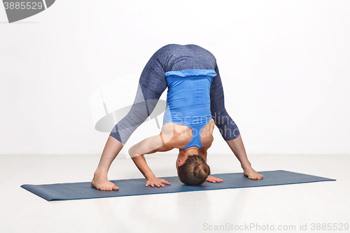 Image of Woman doing yoga asana Prasarita padottanasana