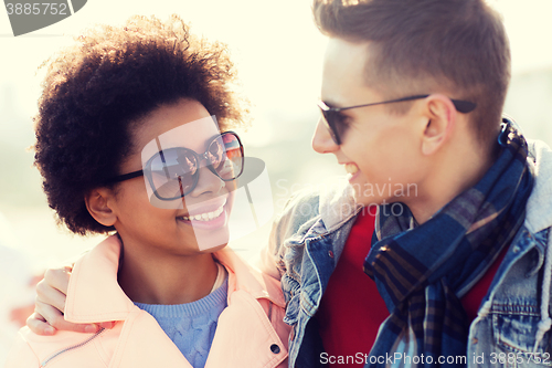 Image of happy teenage friends in shades talking outdoors