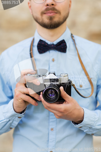 Image of close up of hipster man with film camera in city