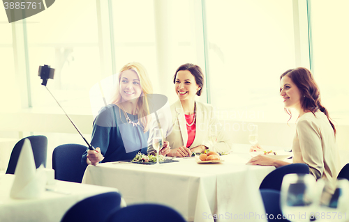 Image of women with smartphone taking selfie at restaurant