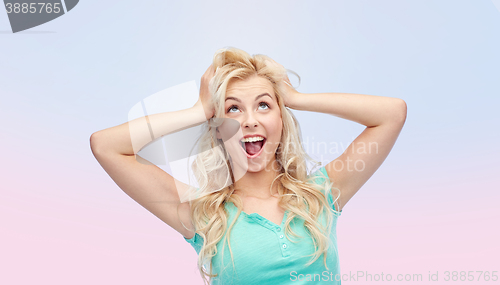 Image of smiling young woman holding to her head or hair