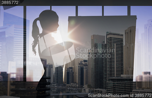 Image of silhouette of woman with flipboard over city