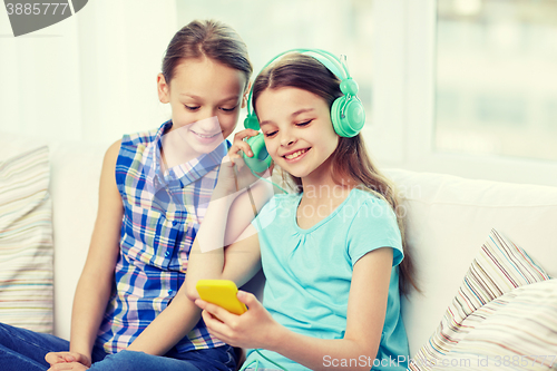 Image of happy girls with smartphone and headphones