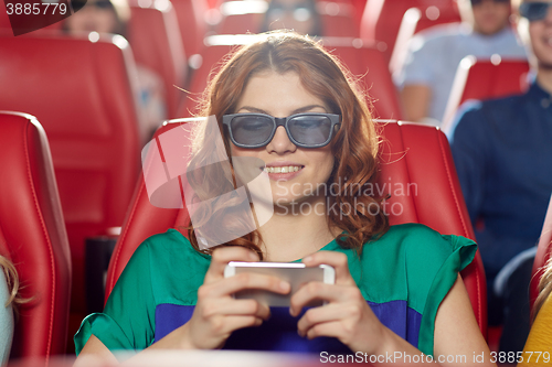 Image of happy woman with smartphone in 3d movie theater