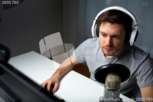 Image of man in headset playing computer video game at home