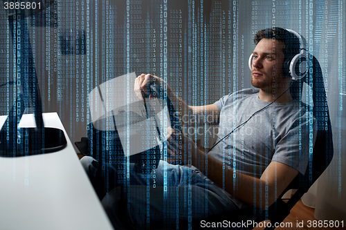 Image of man playing car racing video game at home