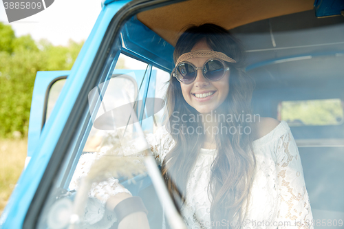 Image of smiling young hippie woman in minivan car