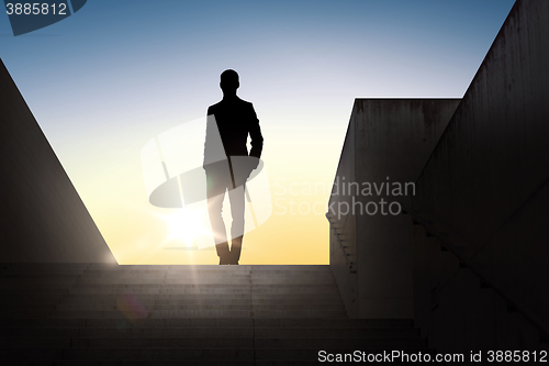 Image of silhouette of businessman over sun light