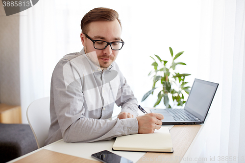 Image of creative man or businessman writing to notebook