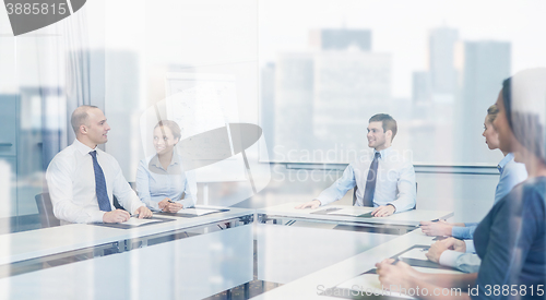 Image of group of smiling businesspeople meeting in office