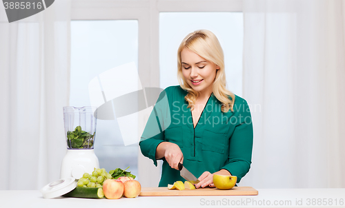 Image of smiling woman with blender cooking food at home
