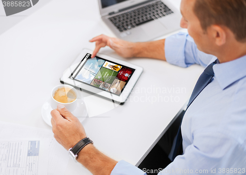 Image of businessman with tablet pc and coffee in office