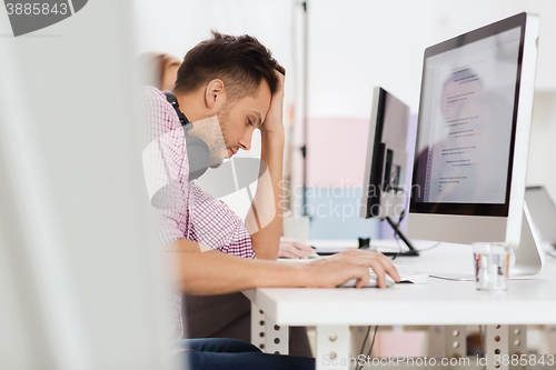 Image of stressed software developer at office