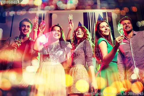 Image of smiling friends with glasses of champagne in club