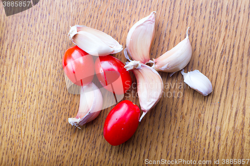 Image of tomato garlic on a wooden kitchen table