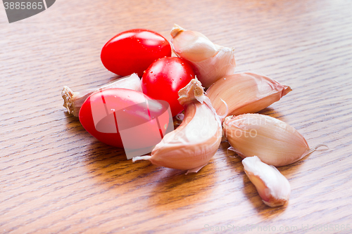 Image of tomato garlic on a wooden kitchen table