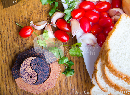 Image of top-view of a wood table with olives tomatoes bread