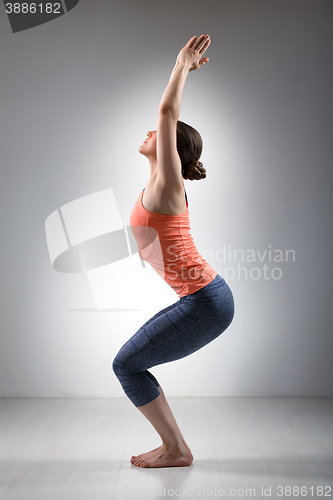 Image of Woman doing ashtanga vinyasa yoga asana Utkatasana