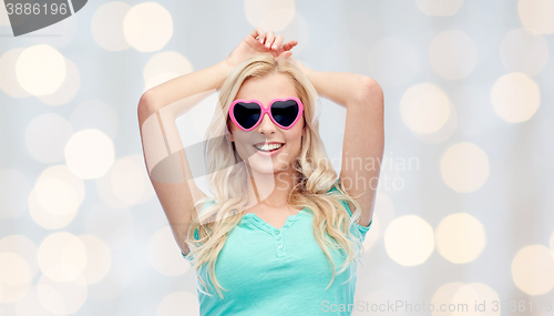 Image of happy young woman in heart shape sunglasses