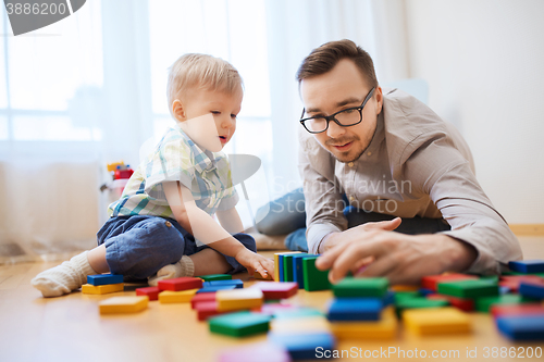 Image of father and son playing with toy blocks at home