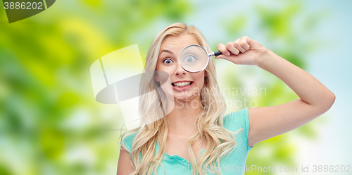 Image of happy young woman with magnifying glass