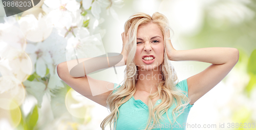 Image of young woman holding to her head and screaming