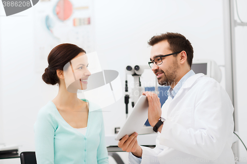 Image of optician with tablet pc and patient at eye clinic