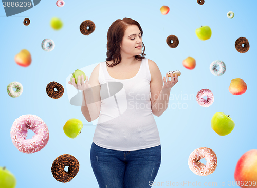 Image of young plus size woman choosing apple or donut