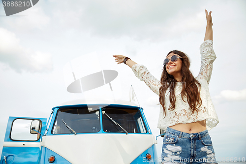 Image of smiling young hippie woman in minivan car