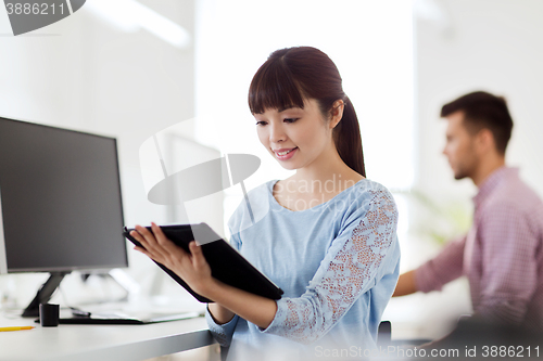 Image of happy creative female office worker with tablet pc