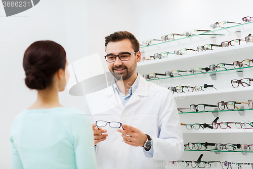 Image of woman and optician showing glasses at optics store