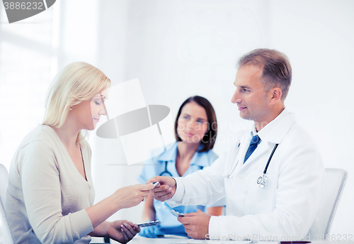 Image of doctor giving tablets to patient in hospital