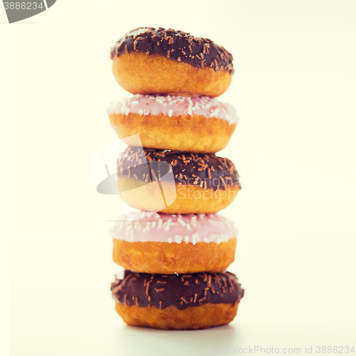 Image of close up of glazed donuts pile over white